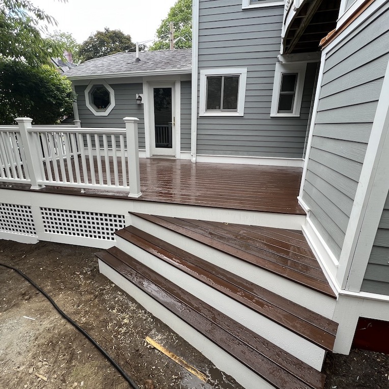 A recently-built wooden patio with dark brown stairs and 
