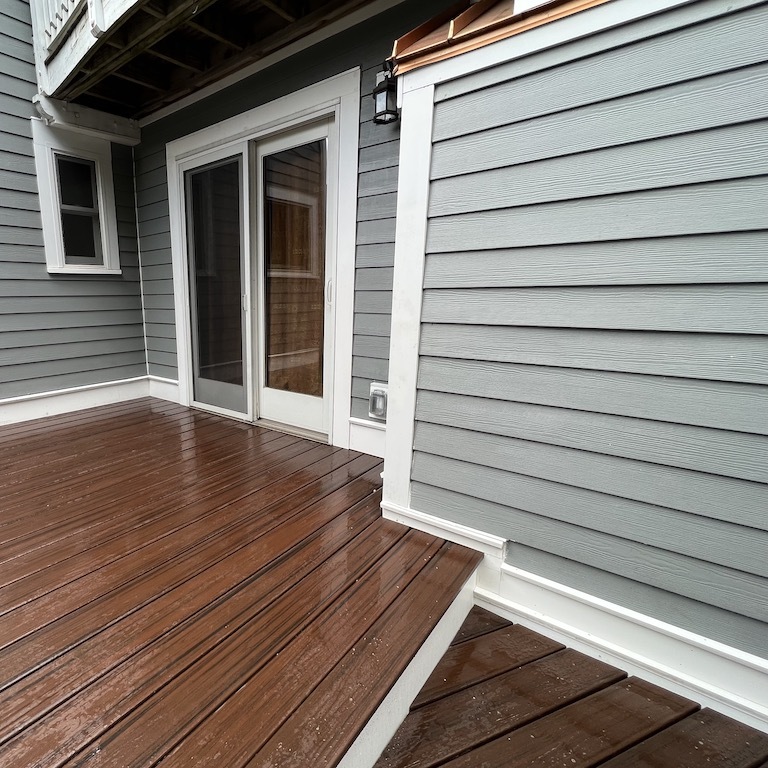 A fresh perspective on a recently installed wooden patio for a residential home, focusing on the doorway to the outside