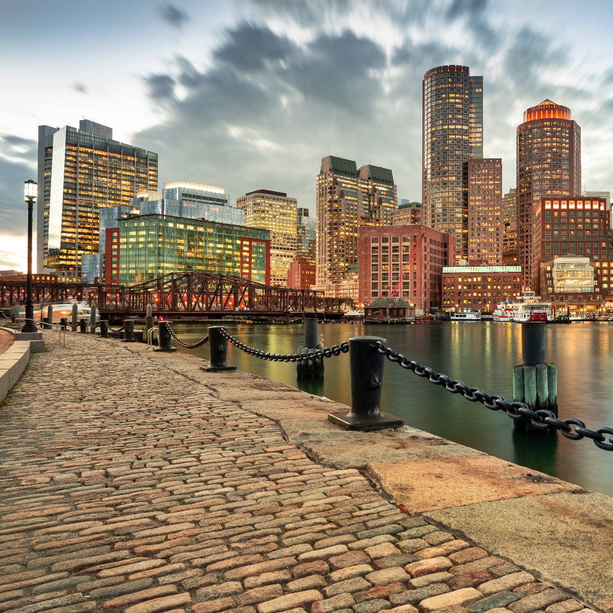Downtown skyline city view of Boston Massachusetts USA looking over the riverfront harbor and marina boat dock from Fan Pier Park at night
